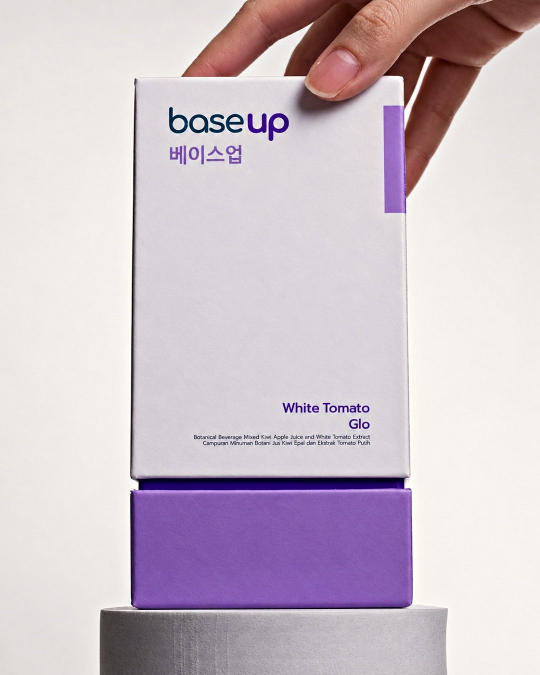 A hand setting a White Tomato Glo box on a stand